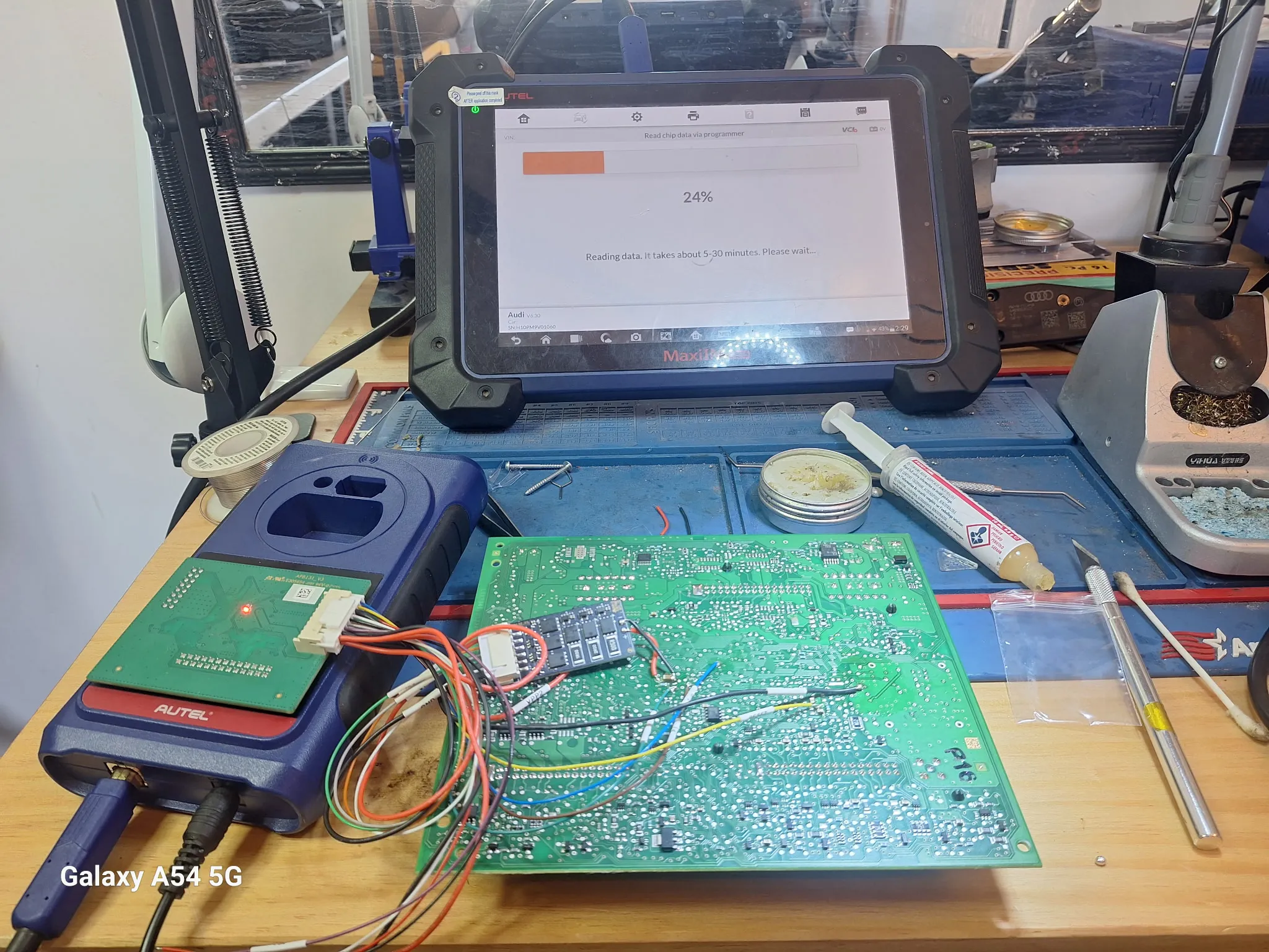 A circuit board connected to a diagnostics device reading data.