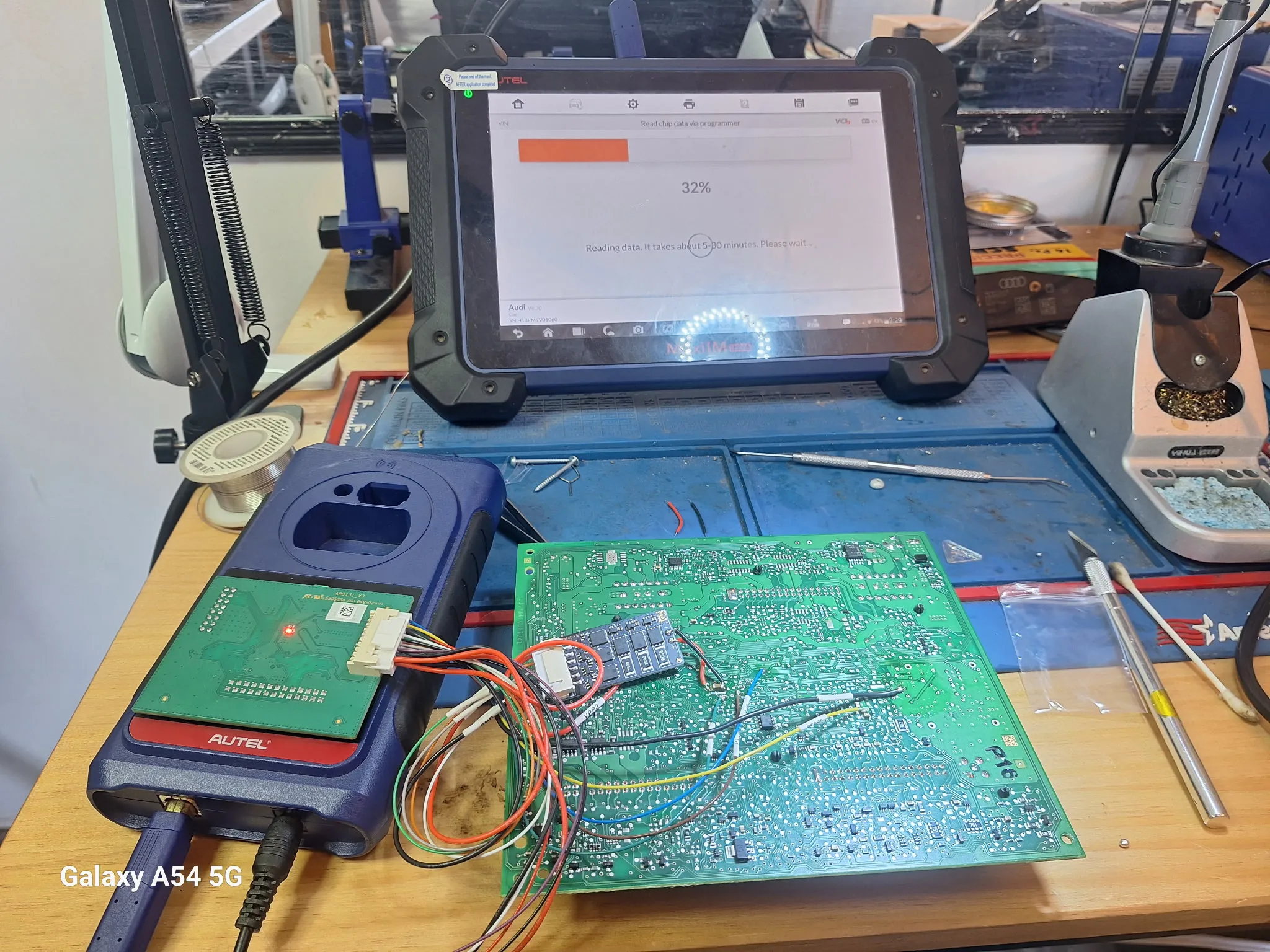 A circuit board connected to a diagnostics device reading data.