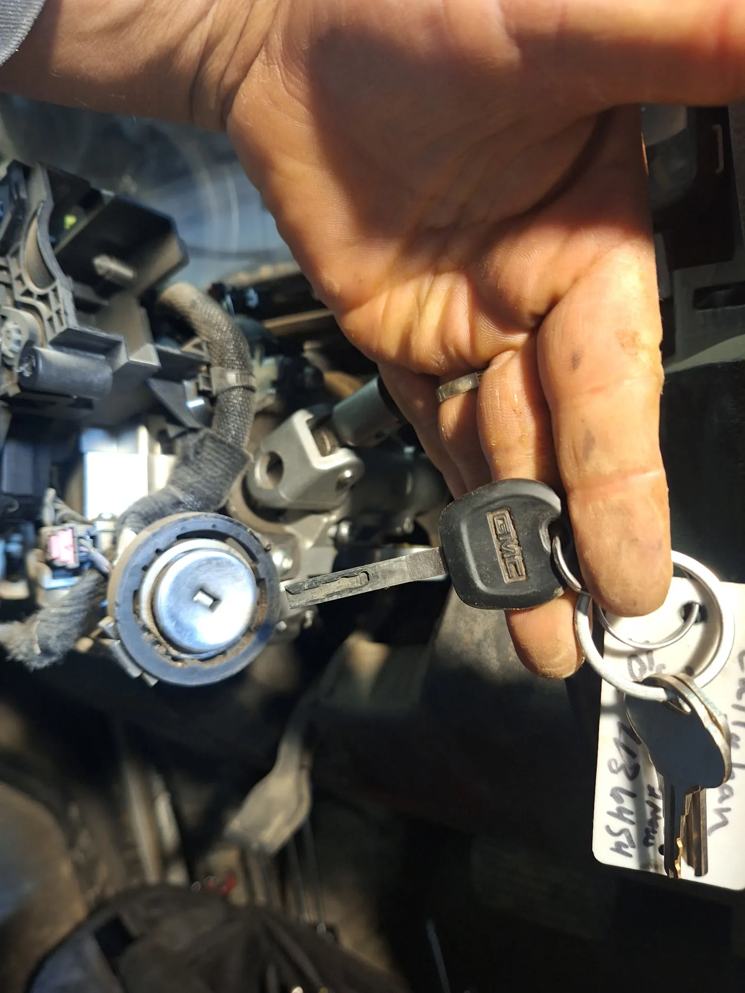 A partially disassembled ignition mechanism next to the corresponding GMC key.