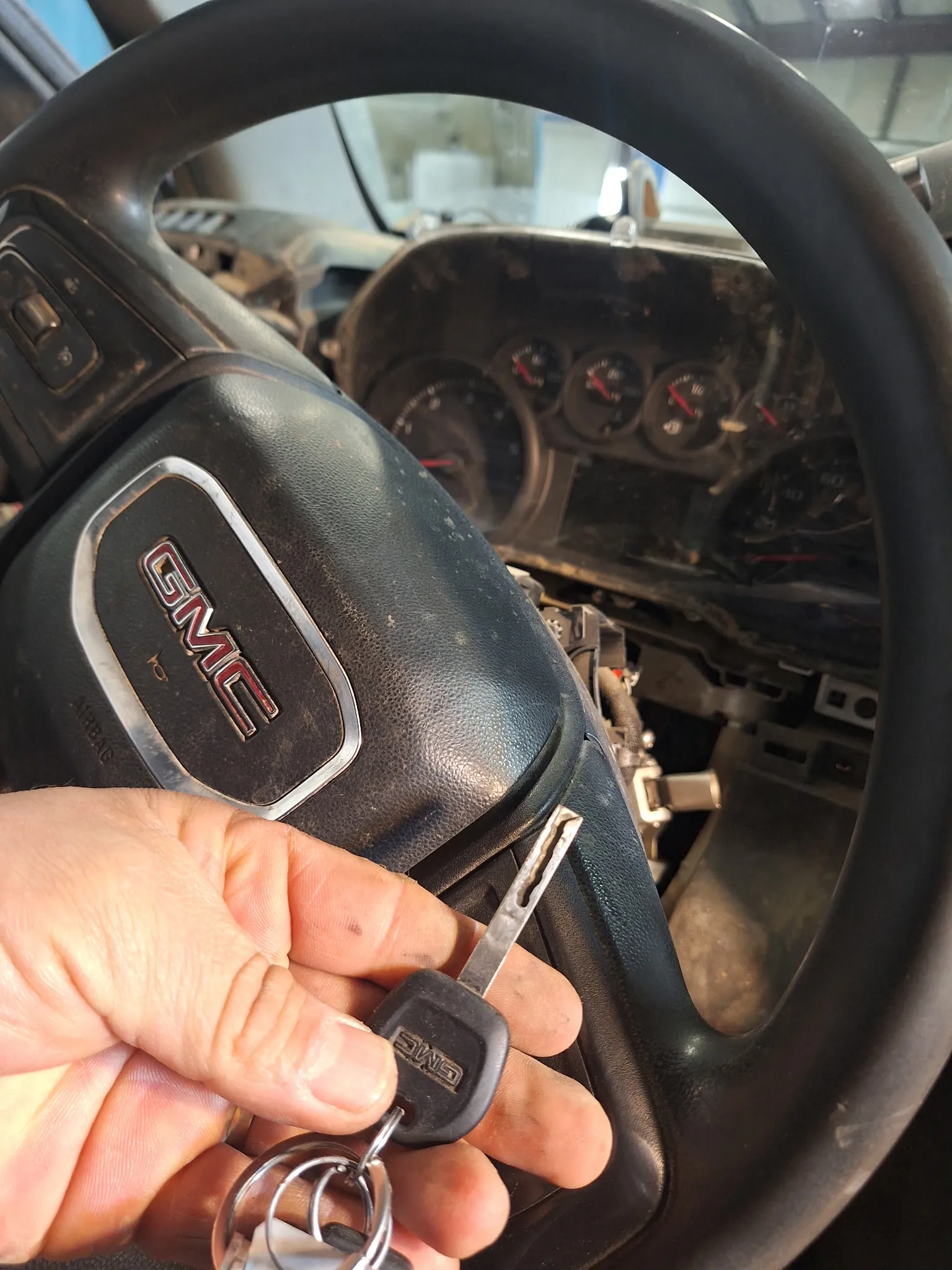 A partially disassembled ignition mechanism next to the corresponding GMC key.