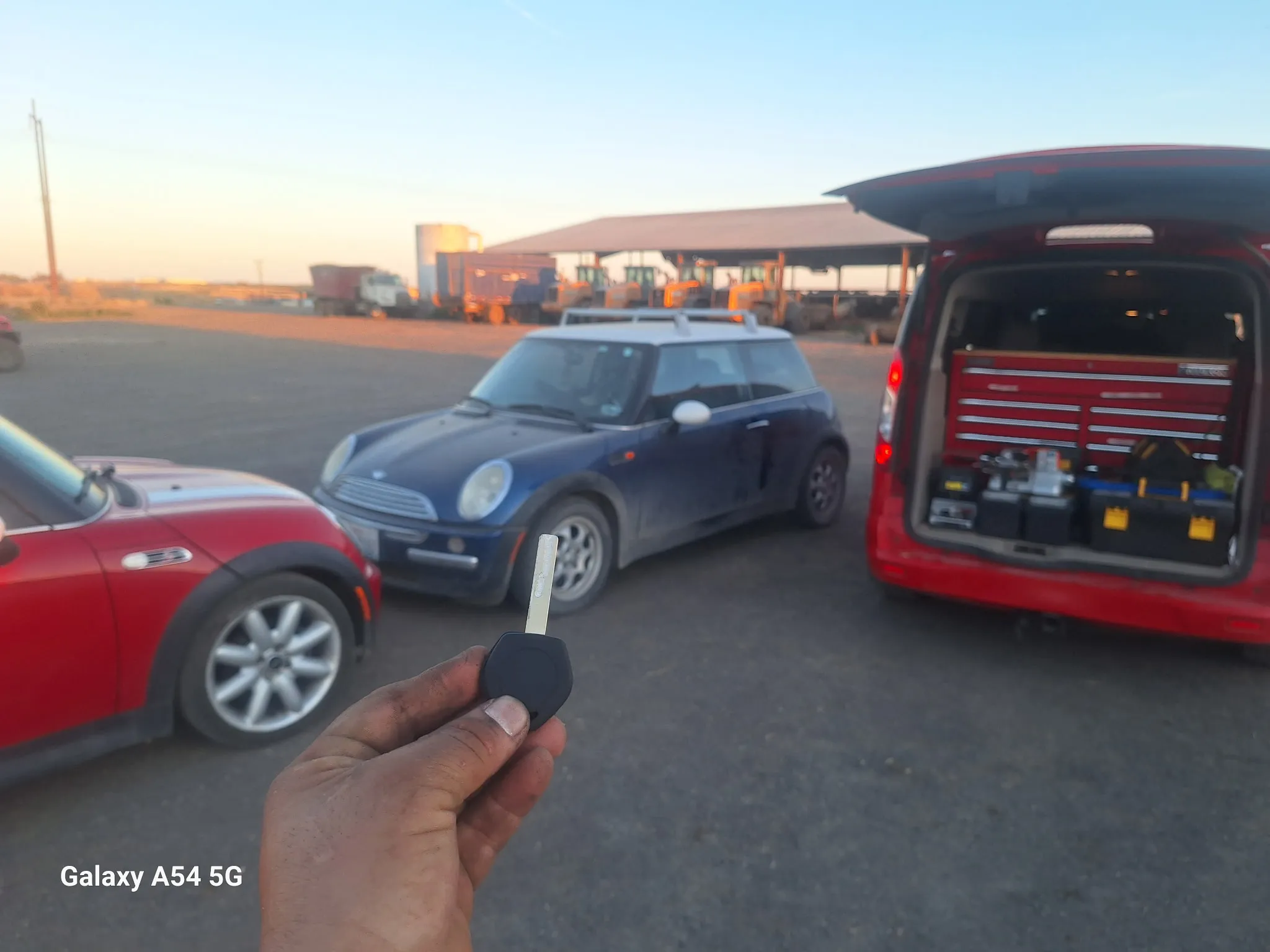 A car key in front of a blue MINI Cooper.